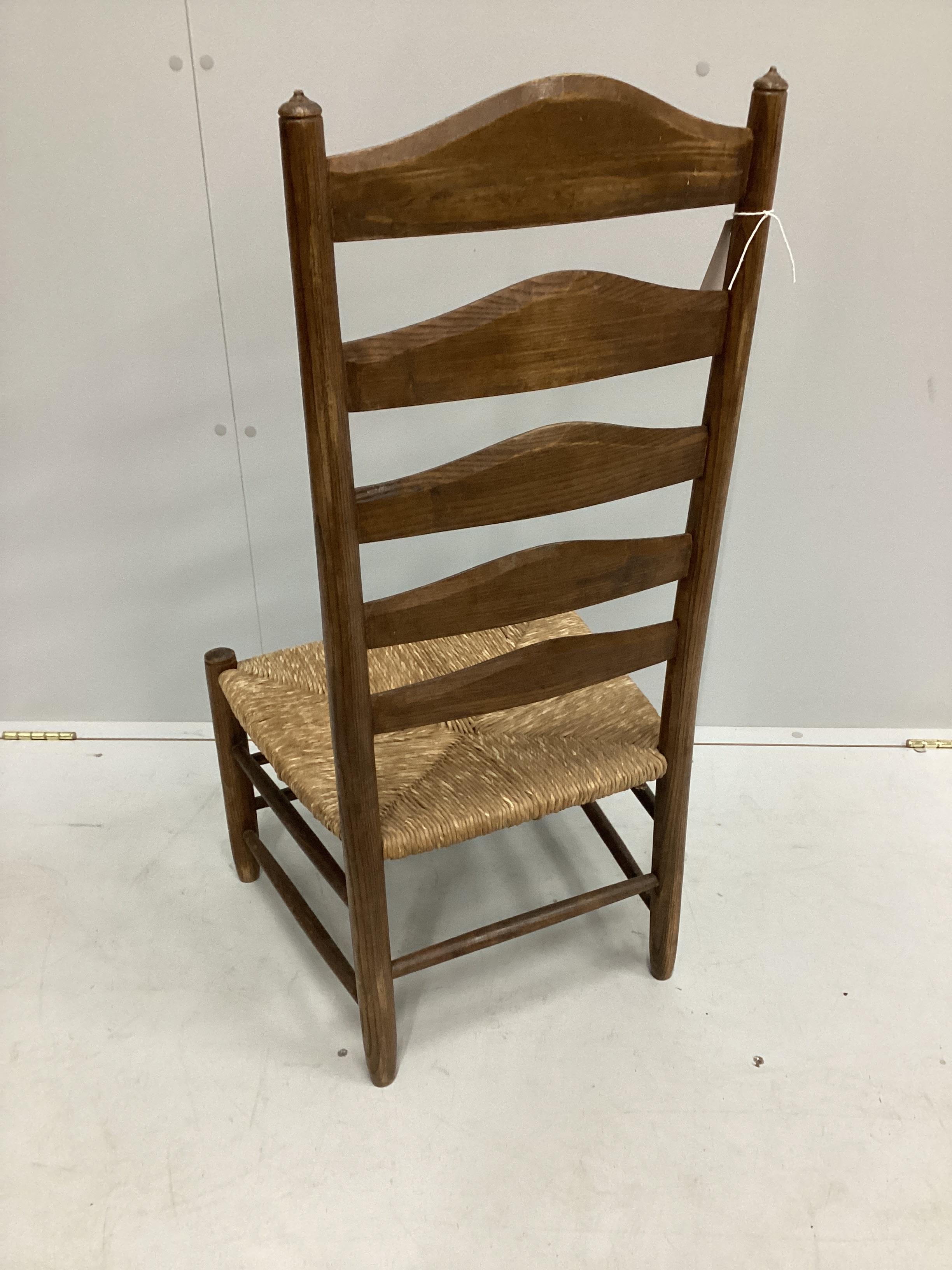 An early 20th century Arts and Crafts ash rush seat ladderback nursing chair possibly by Edward Gardner, width 46cm, depth 40cm, height 93cm